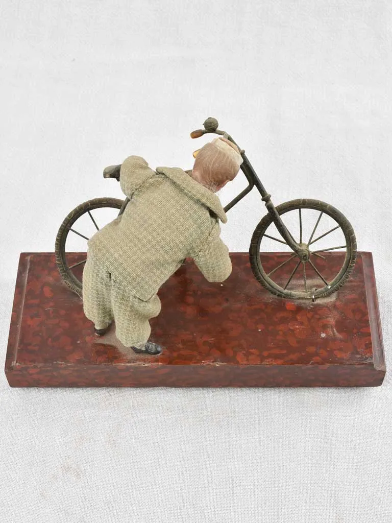 1910's artistic sculpture of an old fellow repairing his bicycle 8¼"